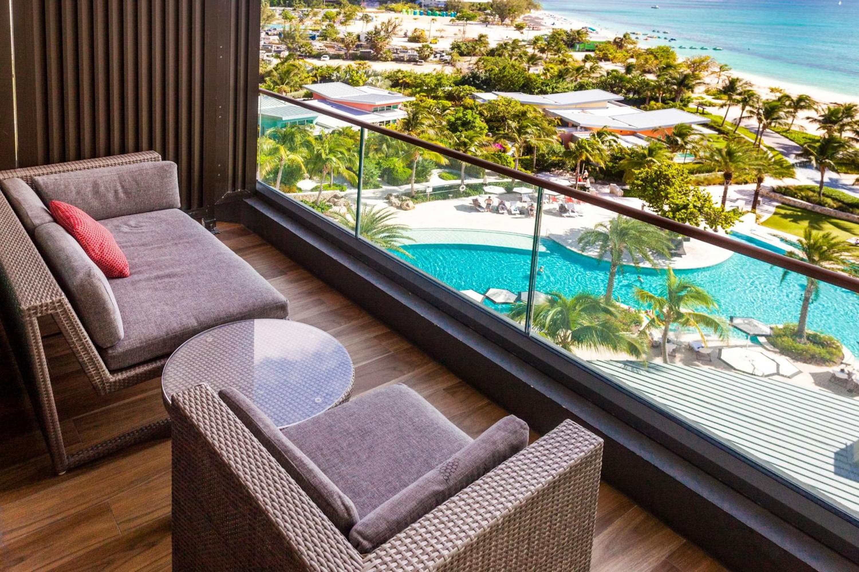 Ocean-view balcony overlooking the pool and beach at Kimpton Seafire Resort + Spa, Grand Cayman