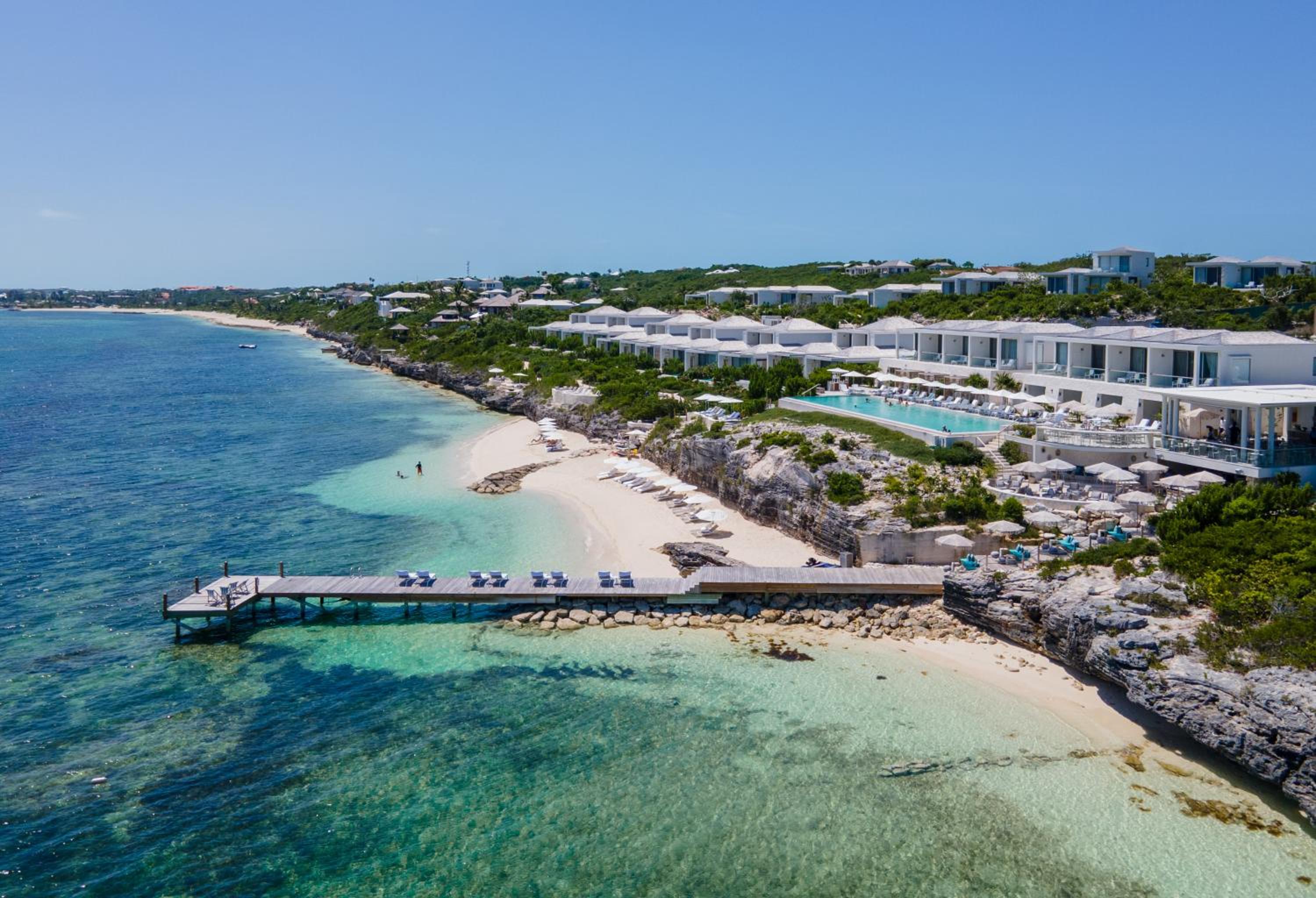 Aerial view of the cliffside pool, dock, and beach at Rock House, Turks and Caicos